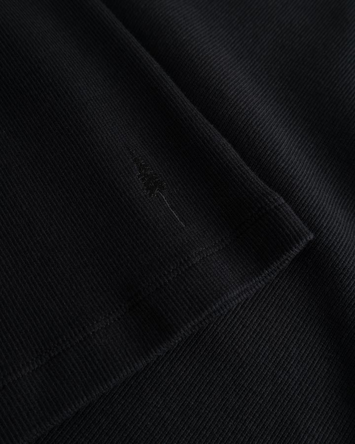 NIKIN  women , black, ribbed fabric with delicate decorative stitching along the hem, pleated.